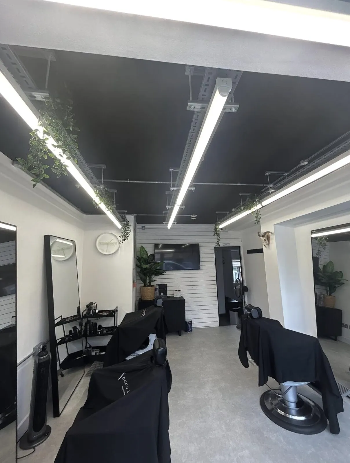 Barber shop interior with sprayed black ceiling and white shiplap walls