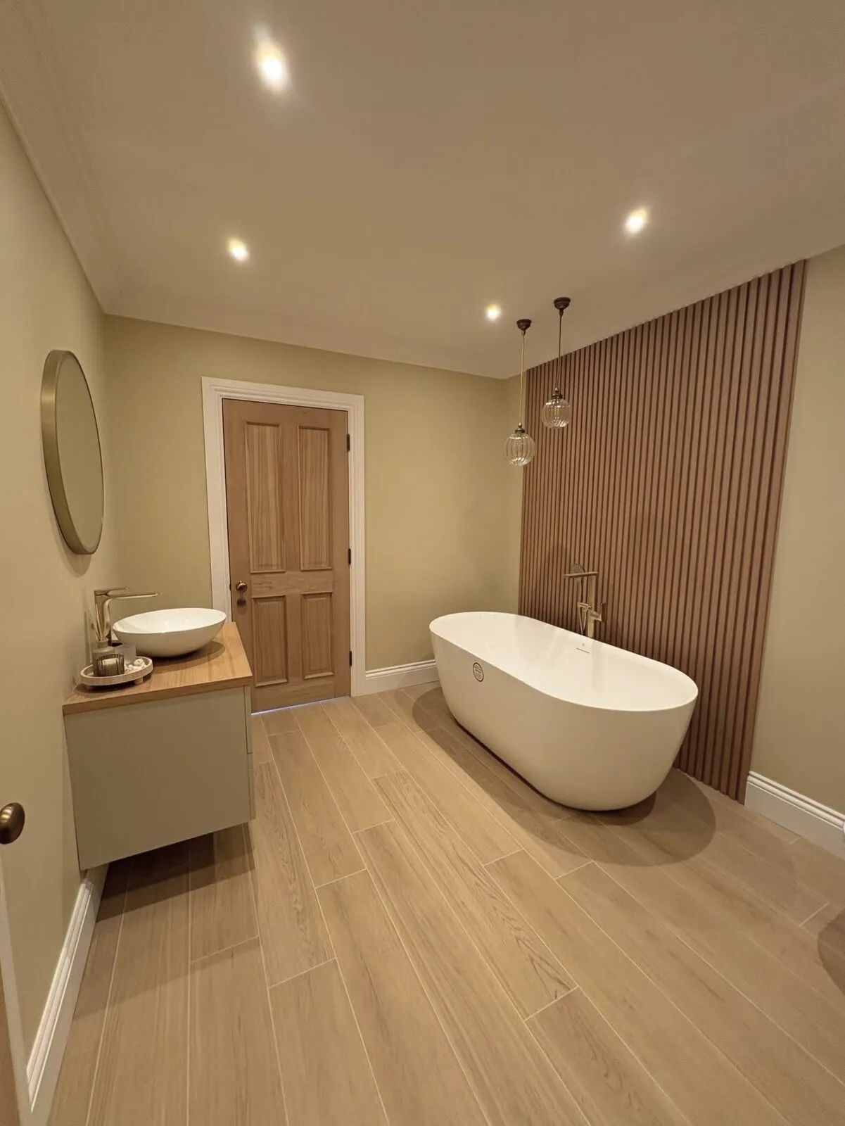 Bathroom decorated in a warm neutral with a slatted timber feature wall