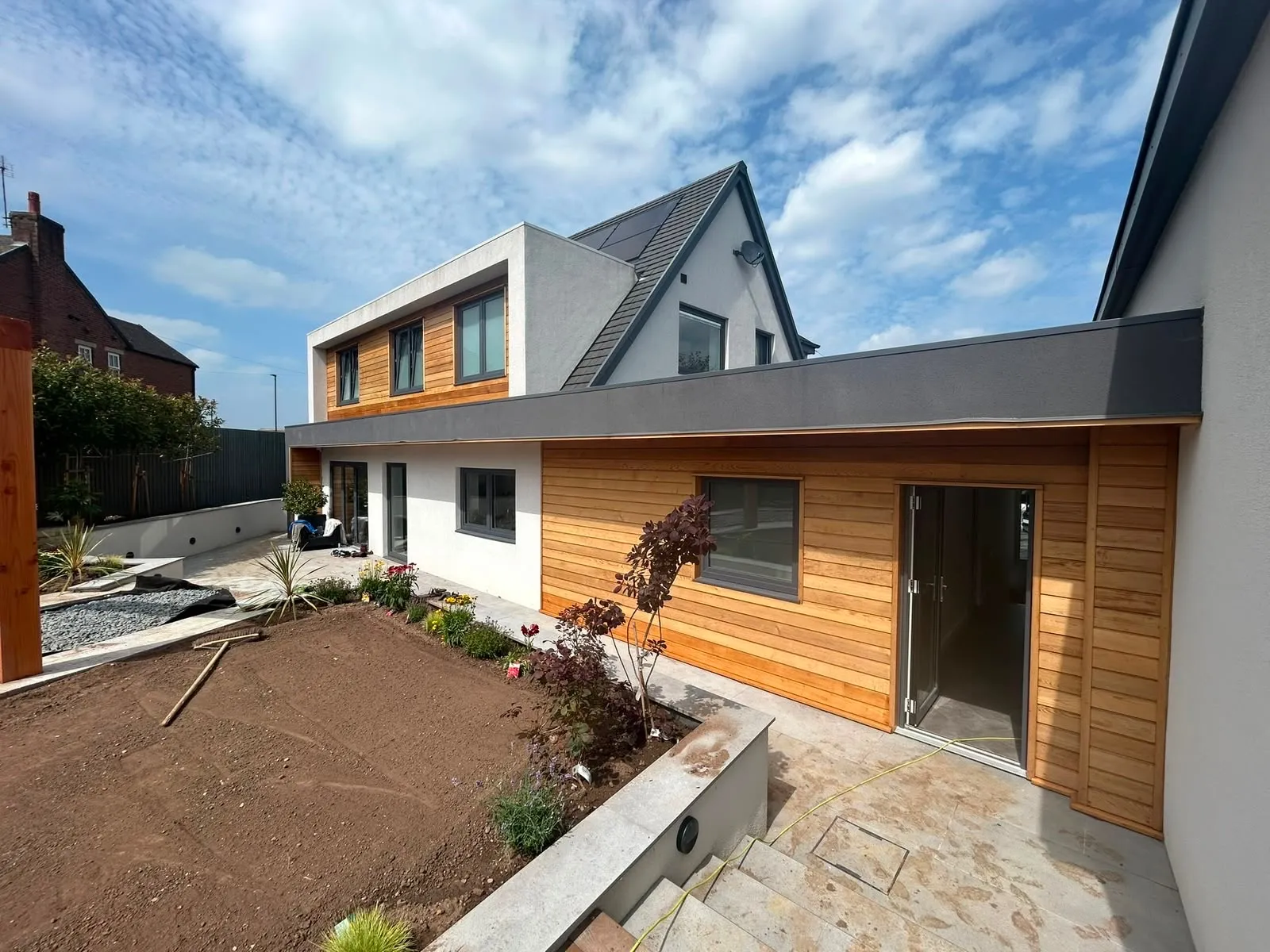 Rear of the same house, with the oak clad single-storey extension and dormer above it