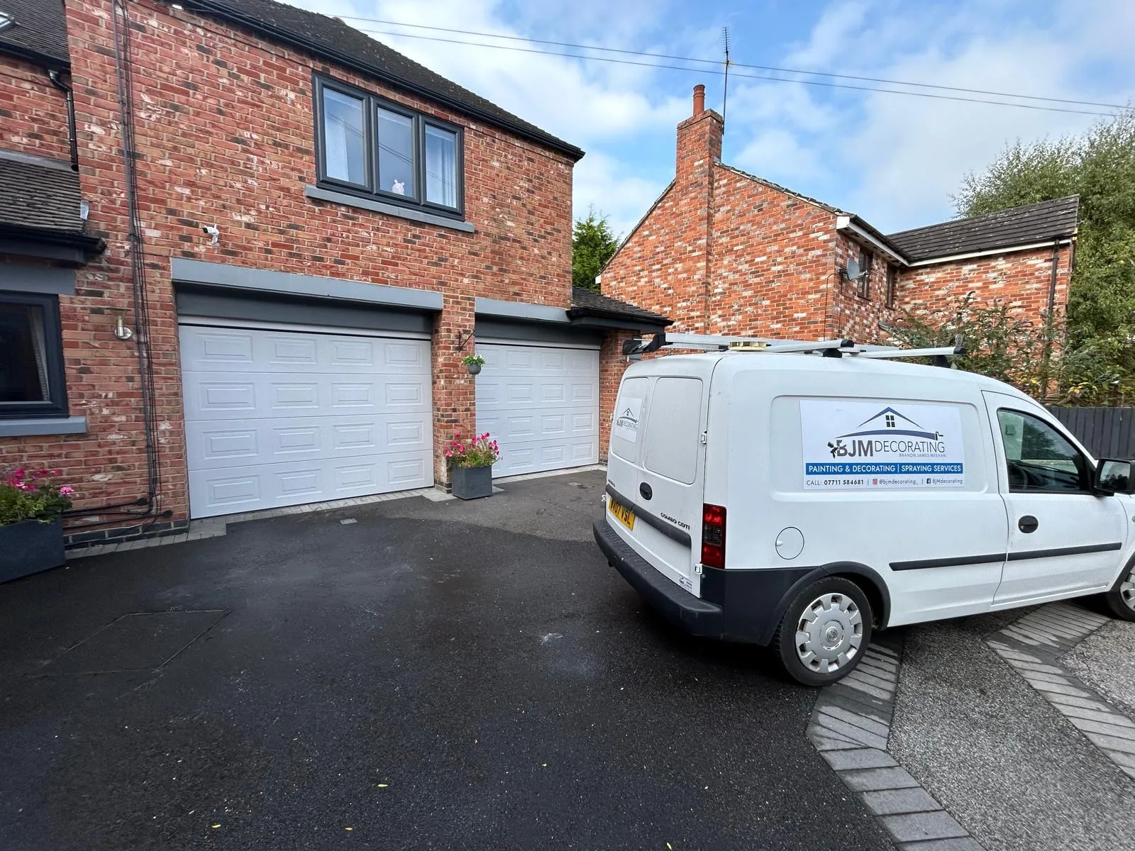 Pair of garage doors sprayed white, with the BJM Decorating van on the driveway