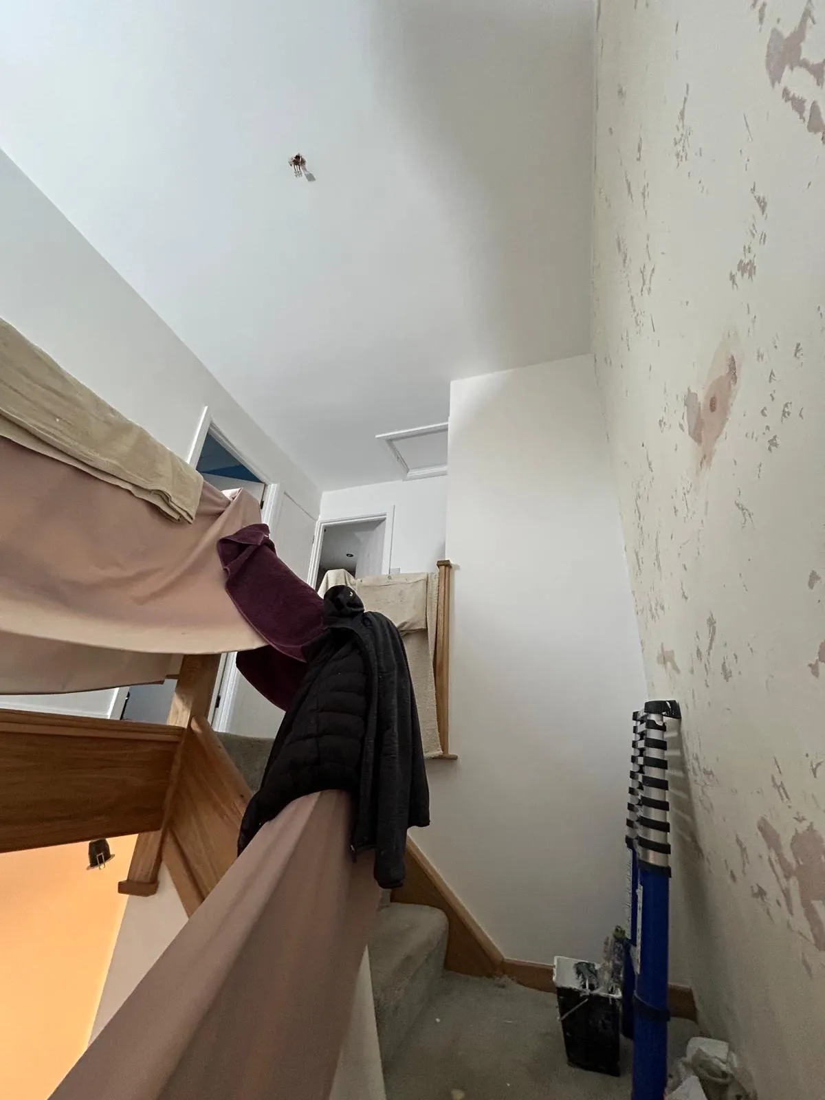 Landing with a freshly painted white ceiling and one wall still stripped