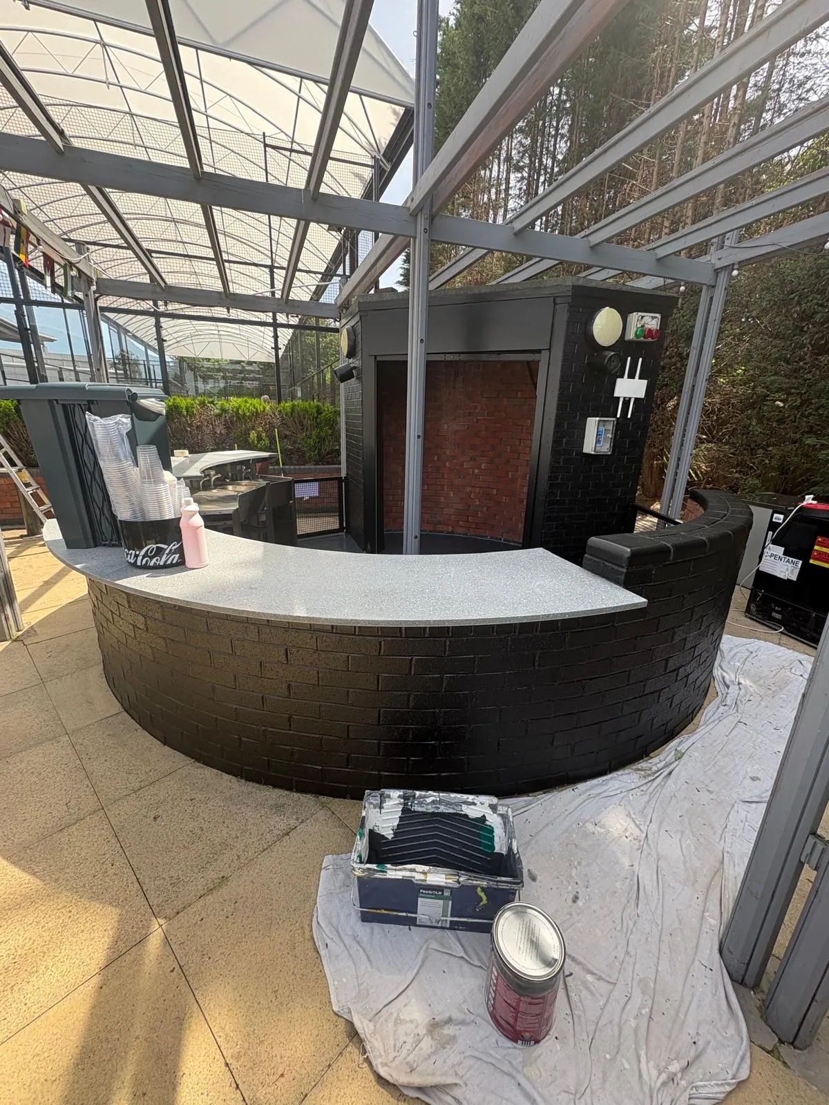 The same terrace mid-job, with the bar front painted black and the back wall still bare red brick